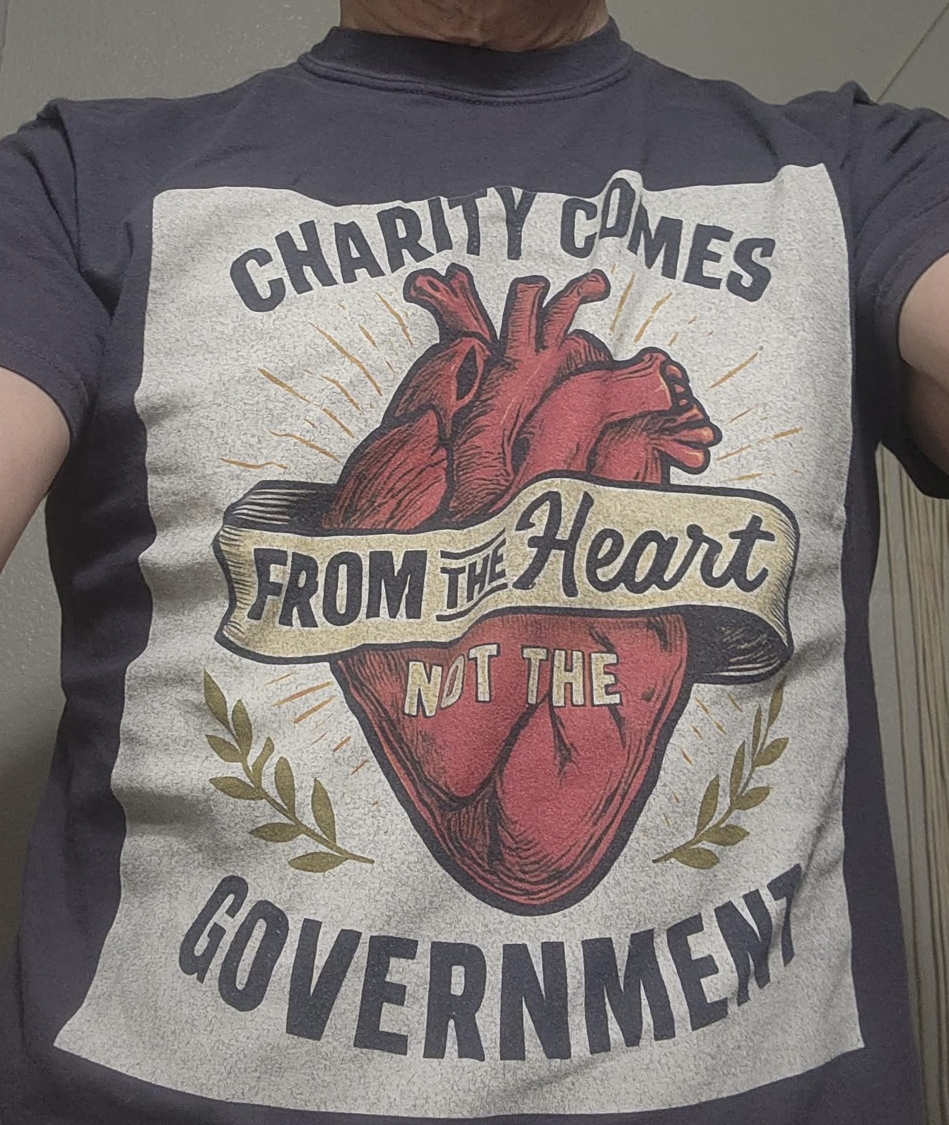 Mike Shaner wearing the Charity Comes From the Heart, Not Government shirt