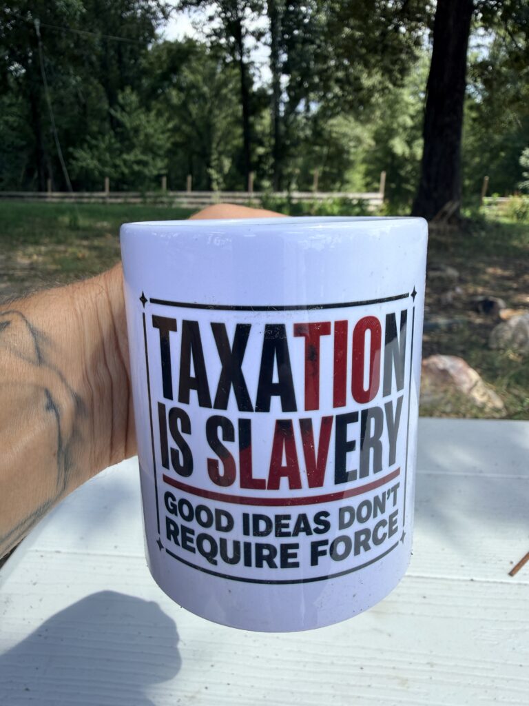 Customer holding the Taxation Is Slavery ceramic mug reading Good Ideas Don’t Require Force, outdoors on a farm